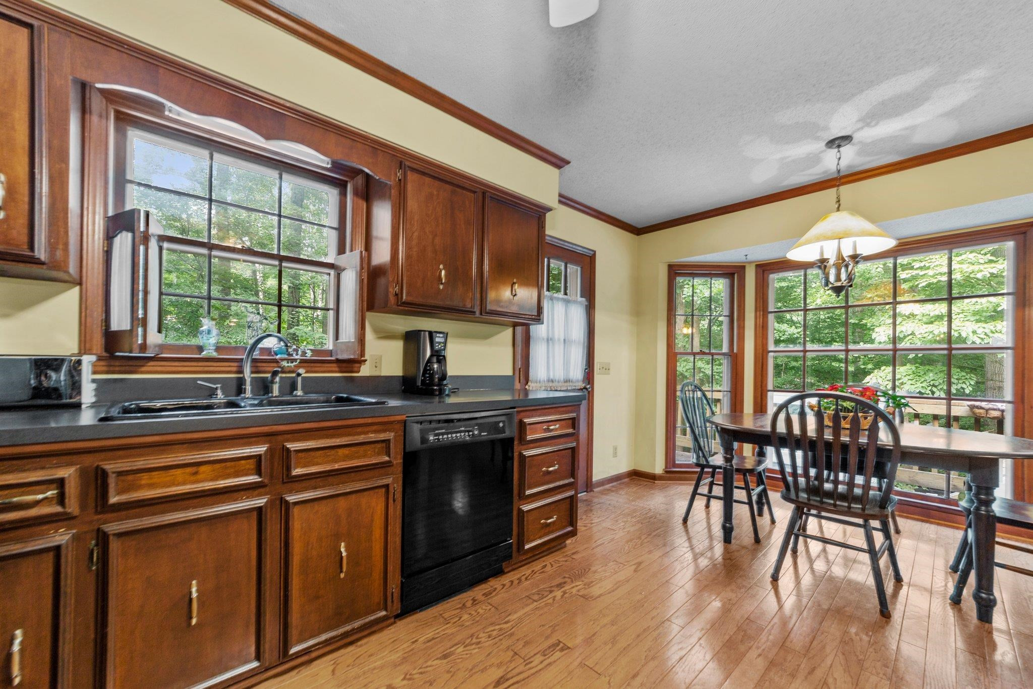 11905 Straight A Way Lane Raleigh, NC 27613 - Photo 19 of 37 a kitchen with stainless steel appliances granite countertop a stove top oven a sink dishwasher a dining table and chairs with wooden floor