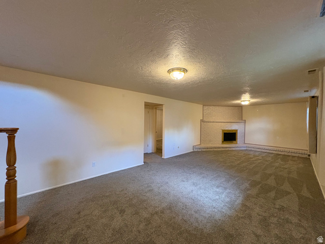 595 Meadowlark Road Orem, UT 84097 - Photo 51 of 87 Spacious room featuring neutral carpet flooring, a corner brick fireplace with a hearth, and light-colored walls
