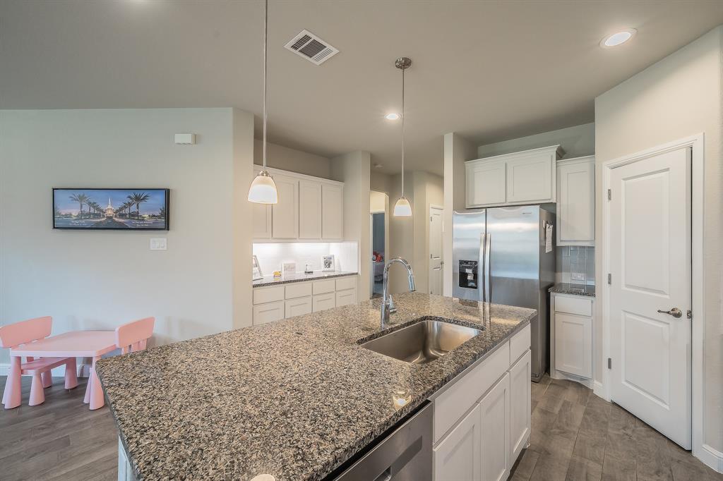 1212 Bosque Lane Weatherford, TX 76087 - Photo 7 of 38 a kitchen with stainless steel appliances granite countertop a sink refrigerator and cabinets