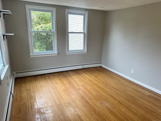 wooden floor in an empty room with a window