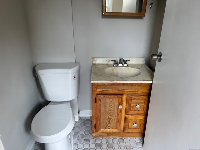 a bathroom with a toilet sink and mirror