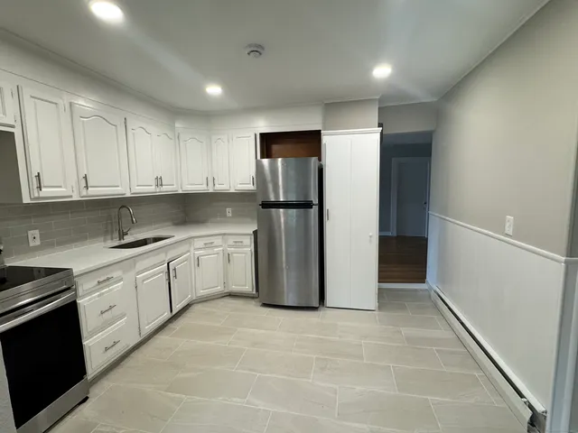 a kitchen with a refrigerator sink and cabinets
