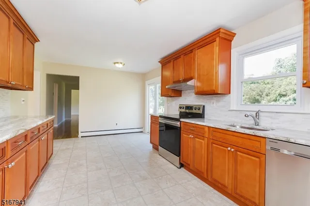 a kitchen with stainless steel appliances granite countertop a sink stove and cabinets