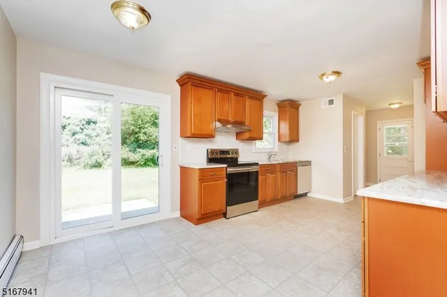 a large kitchen with stainless steel appliances granite countertop a stove a sink dishwasher and a refrigerator