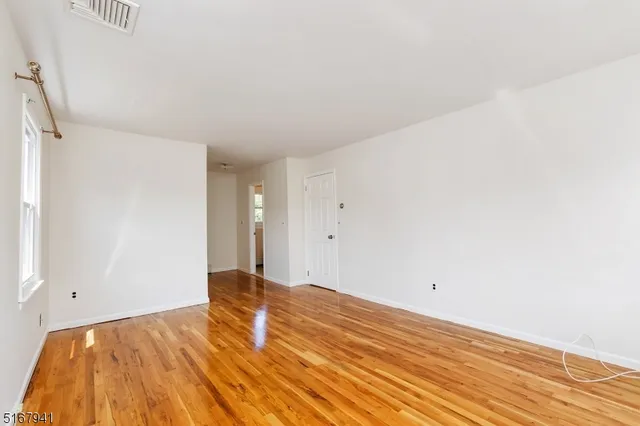 a view of an empty room and wooden floor