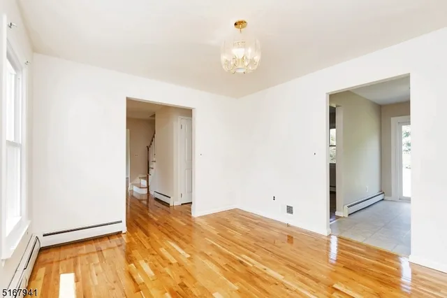 a view of a livingroom with wooden floor and a chandelier