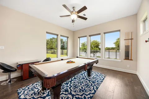 a living room with furniture pool table and a potted plant