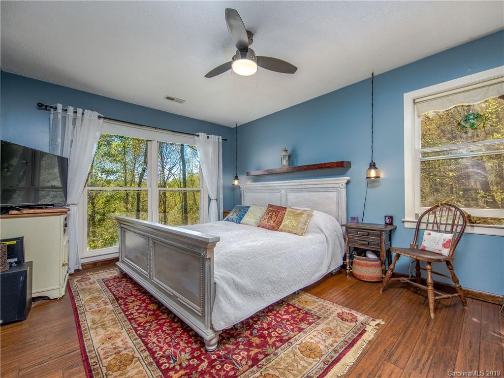 17 Finlay Ridge Road Hendersonville, NC 28739 - Photo 16 of 32 a bedroom with a bed a flat screen tv and a large window