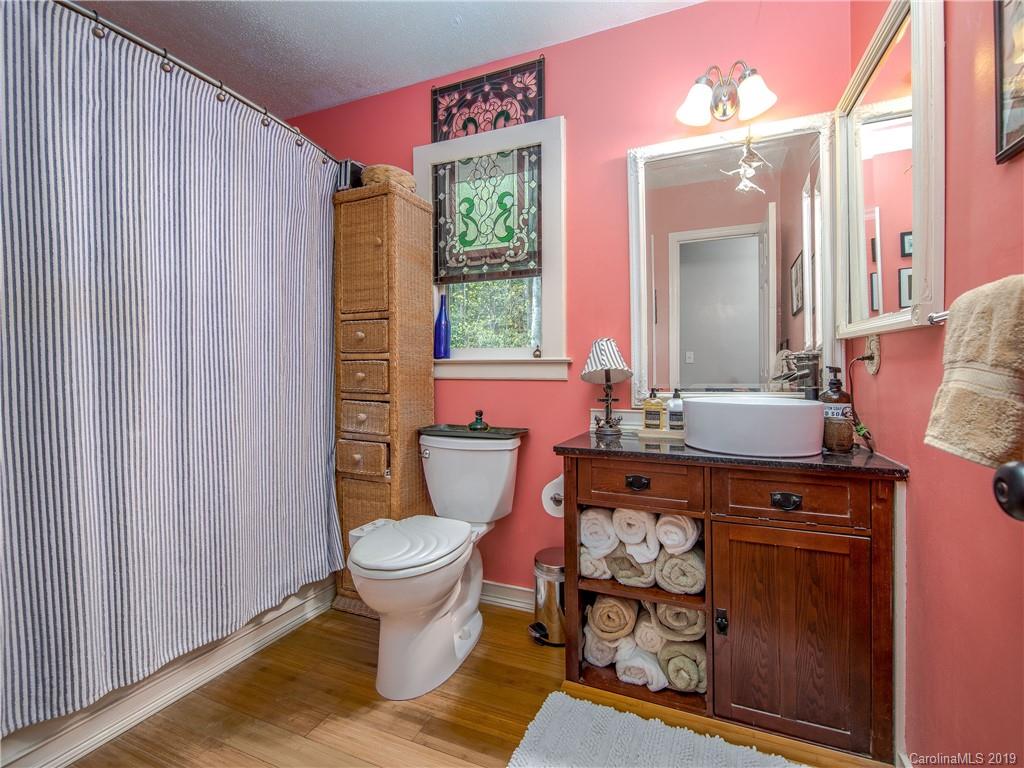 17 Finlay Ridge Road Hendersonville, NC 28739 - Photo 17 of 32 a bathroom with a granite countertop toilet a sink and a mirror