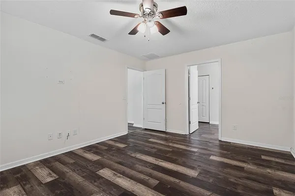 a view of a chandelier fan and wooden floor