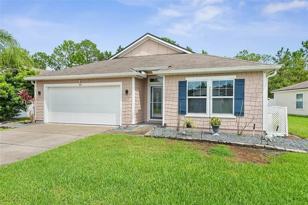 a front view of a house with a yard and outdoor seating