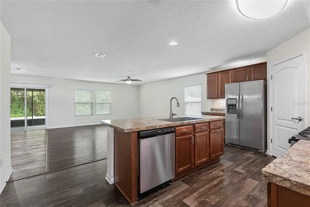 a kitchen with stainless steel appliances granite countertop a sink a stove and a refrigerator