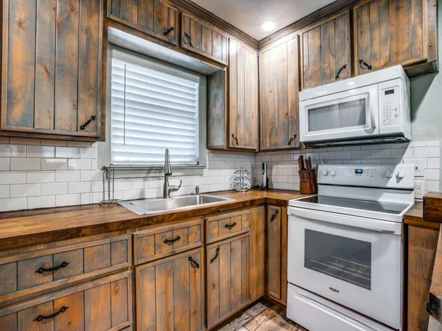 a kitchen with stainless steel appliances granite countertop a sink a stove and cabinets