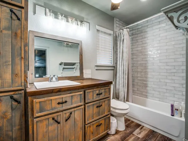 a bathroom with a granite countertop sink toilet and shower