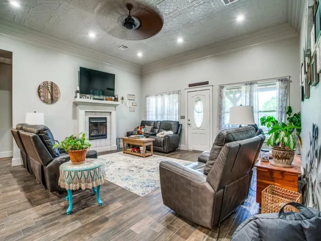 a living room with furniture a fireplace and a flat screen tv