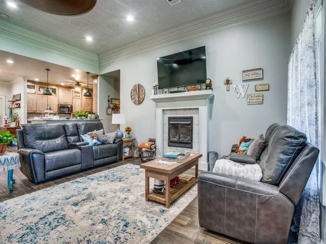 a living room with furniture a flat screen tv and a fireplace