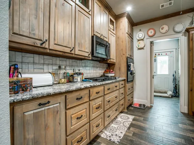 a kitchen with stainless steel appliances granite countertop a sink a stove cabinets and wooden floor