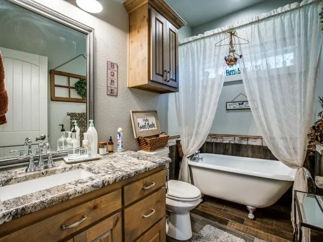 a bathroom with a granite countertop sink a toilet a mirror and shower