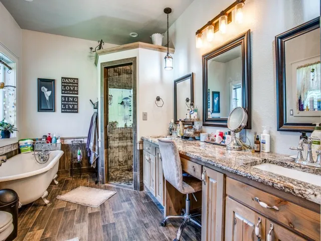 a bathroom with a granite countertop sink mirror and a bathtub