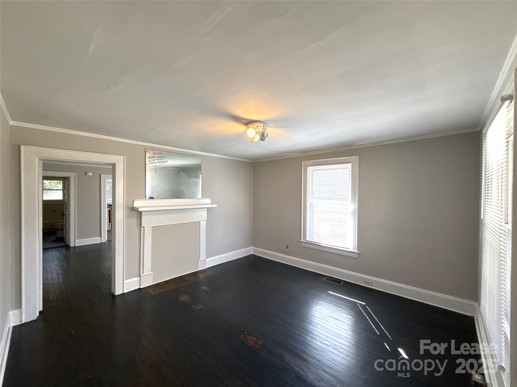 904 Harrill Street Charlotte, NC 28205 - Photo 3 of 11 an empty room with wooden floor and windows