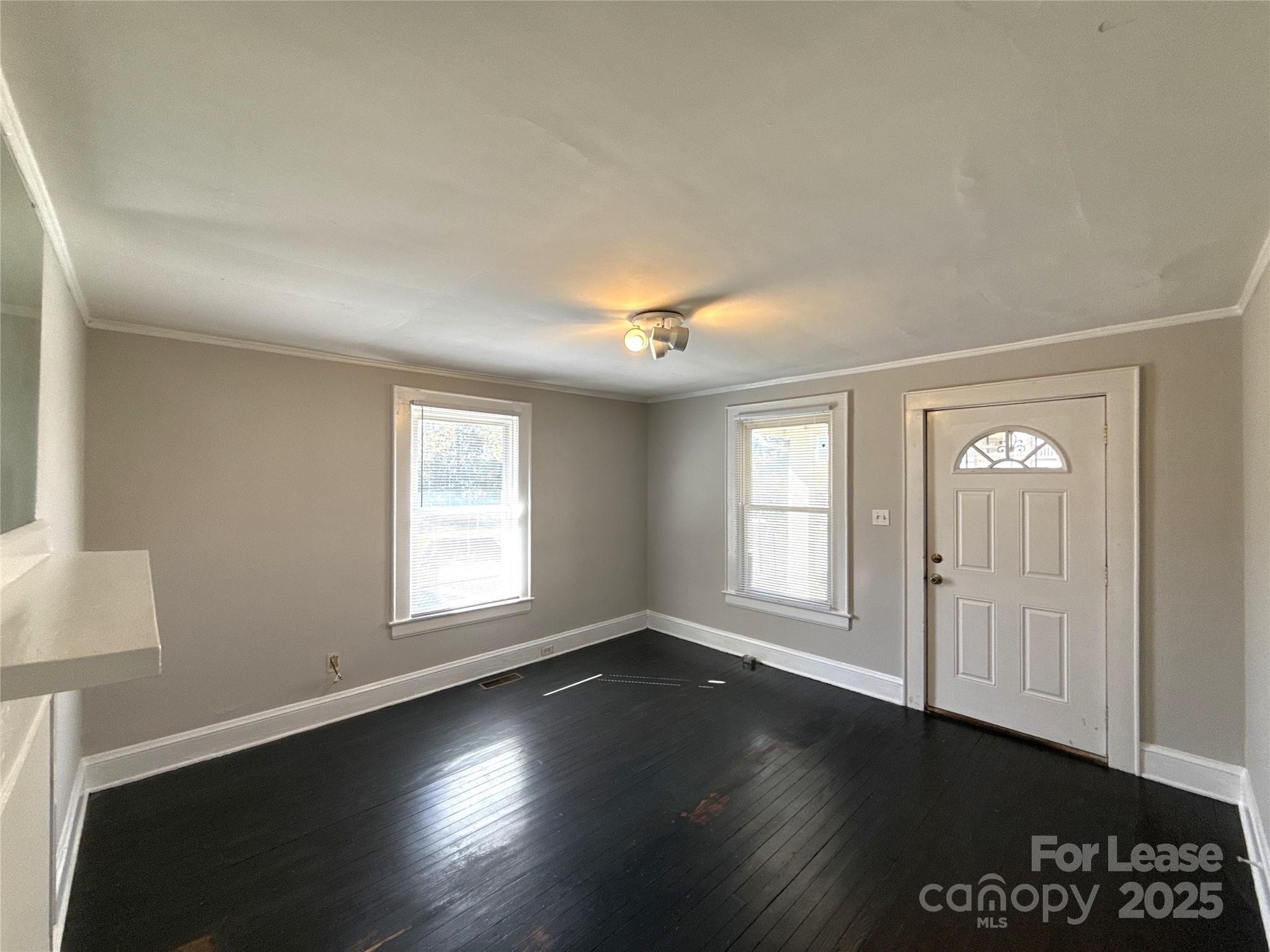 904 Harrill Street Charlotte, NC 28205 - Photo 4 of 11 an empty room with wooden floor and windows