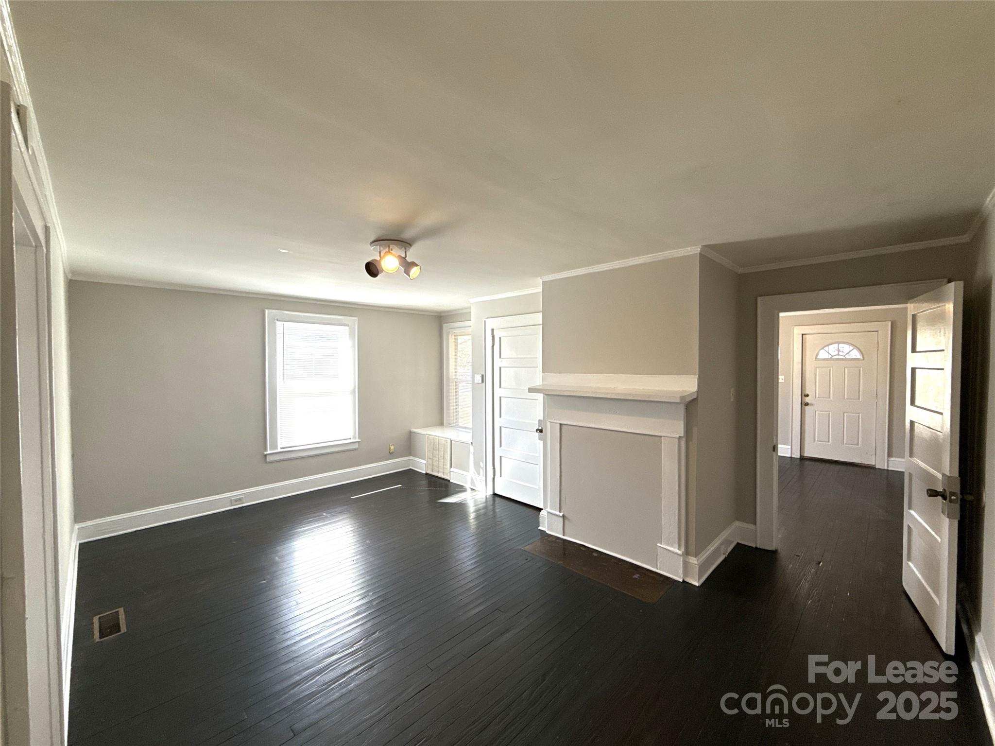904 Harrill Street Charlotte, NC 28205 - Photo 5 of 11 an empty room with wooden floor cabinet and windows