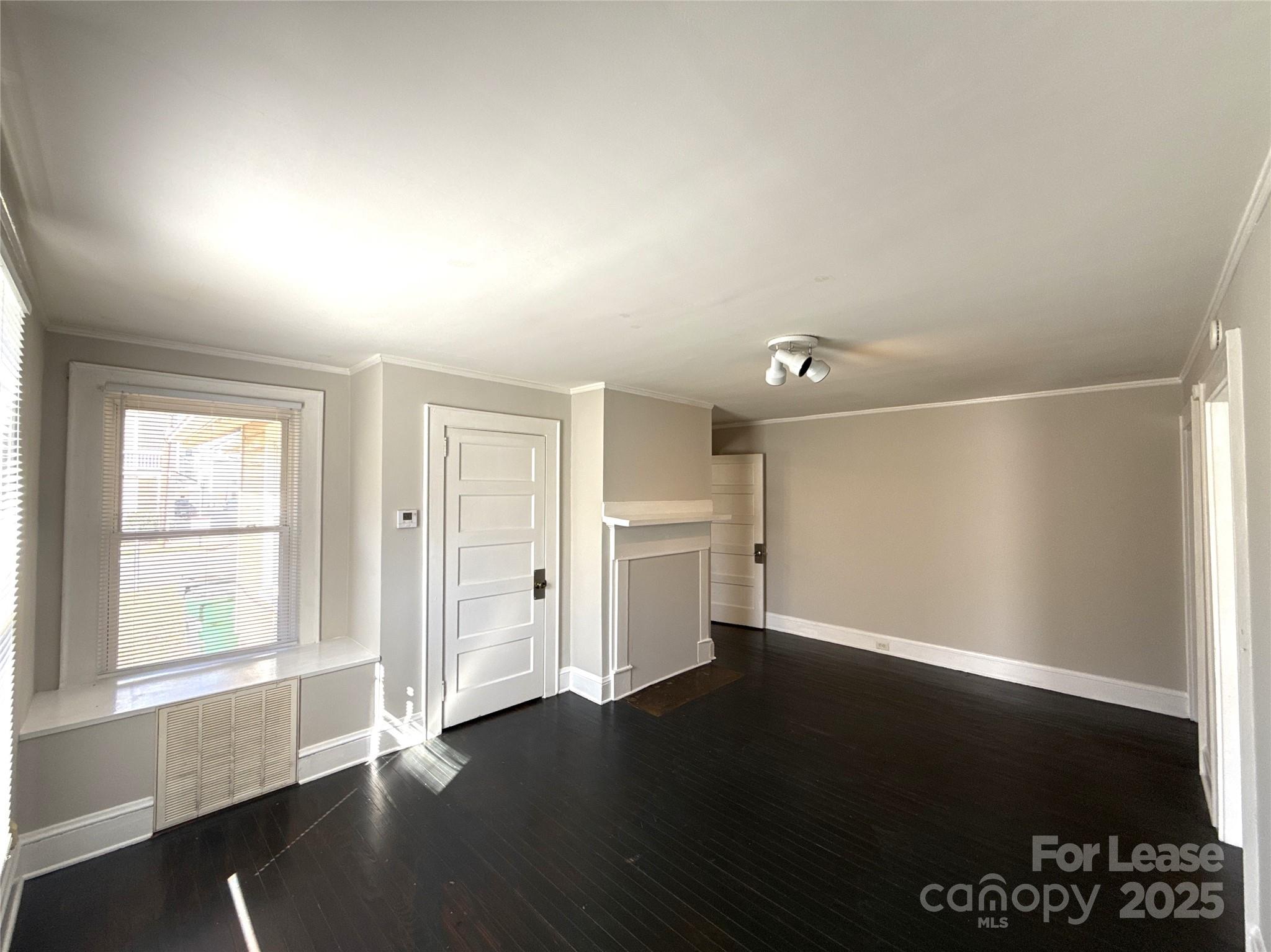 904 Harrill Street Charlotte, NC 28205 - Photo 6 of 11 an empty room with wooden floor and windows