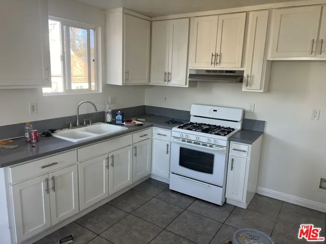 a kitchen with granite countertop white cabinets and white appliances