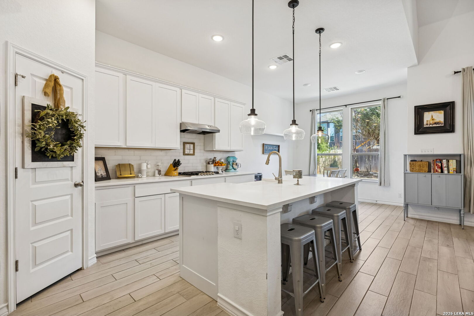 12260 Buckaroo Ranch San Antonio, TX 78254 - Photo 14 of 45 a kitchen that has a lot of white cabinets and wooden floor