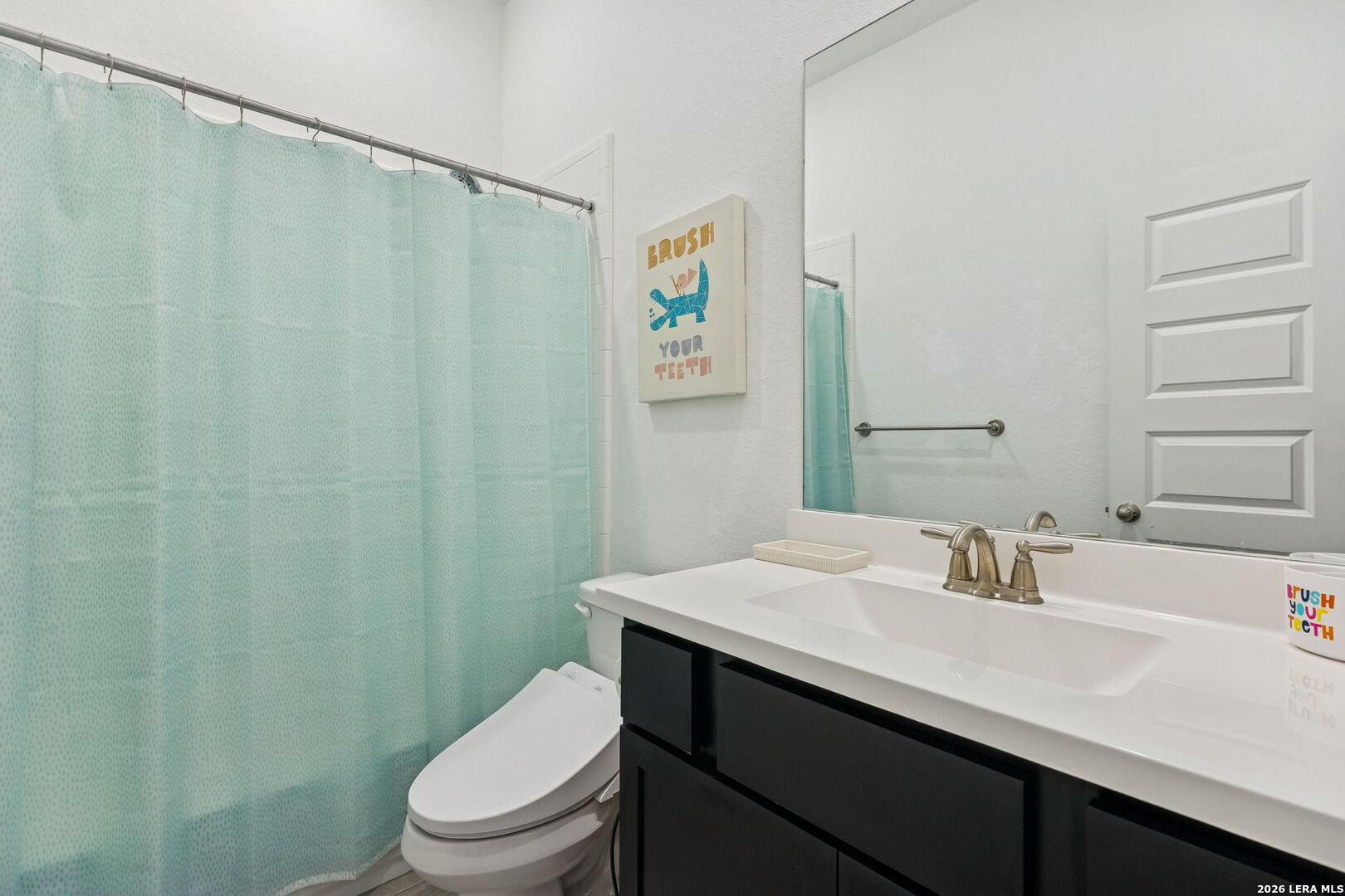 12260 Buckaroo Ranch San Antonio, TX 78254 - Photo 20 of 45 a bathroom with a sink a toilet and shower curtain