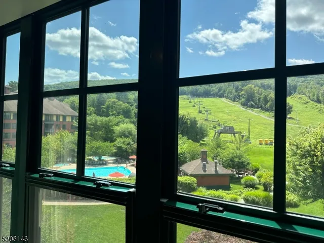 a living room with patio furniture and a chandelier