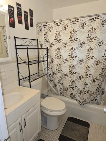 a white toilet sitting next to a shower curtain
