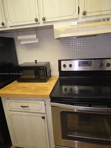 a stove top oven sitting inside of a kitchen