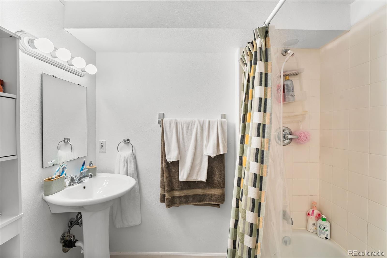 152 Pheasant Run Louisville, CO 80027 - Photo 25 of 30 a bathroom with a sink a mirror and shower