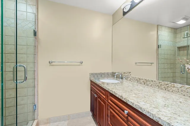 a bathroom with a granite countertop sink and mirror