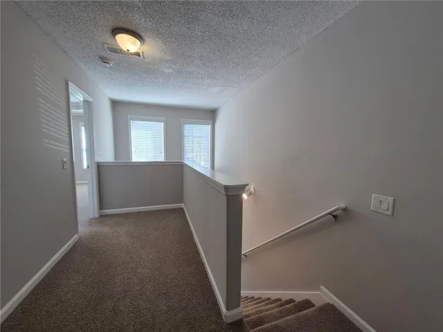 an empty room with ceiling fan and window