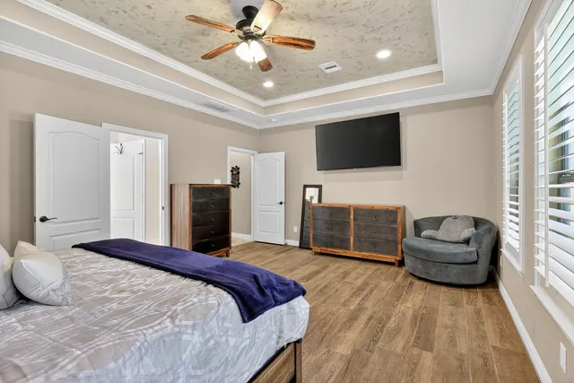 a bedroom with a bed a couch and a flat screen tv