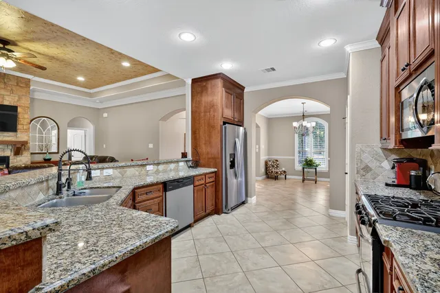 a large kitchen with stainless steel appliances granite countertop a stove and a sink