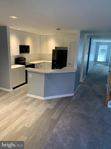 a view of kitchen with microwave stove and cabinets