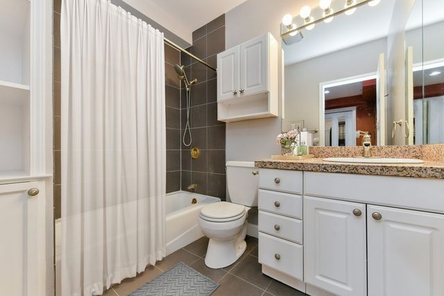 a bathroom with a granite countertop sink toilet and shower