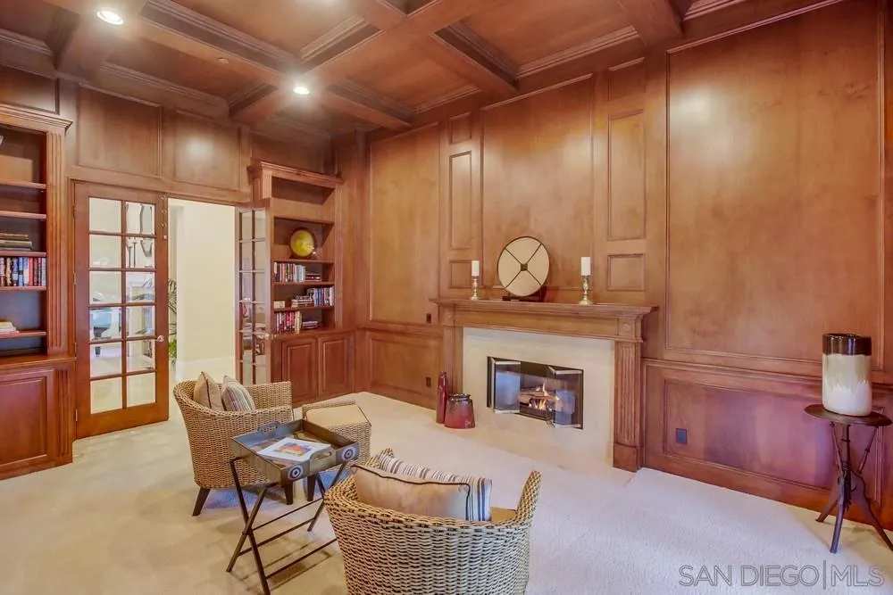 6867 Poco Lago Rancho Santa Fe, CA 92067 - Photo 32 of 52 a living room with furniture a fireplace and a potted plant