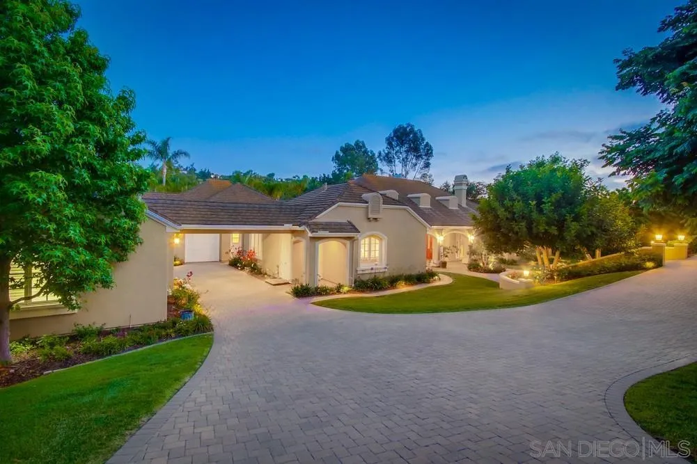 6867 Poco Lago Rancho Santa Fe, CA 92067 - Photo 5 of 52 a front view of a house with a yard and garage
