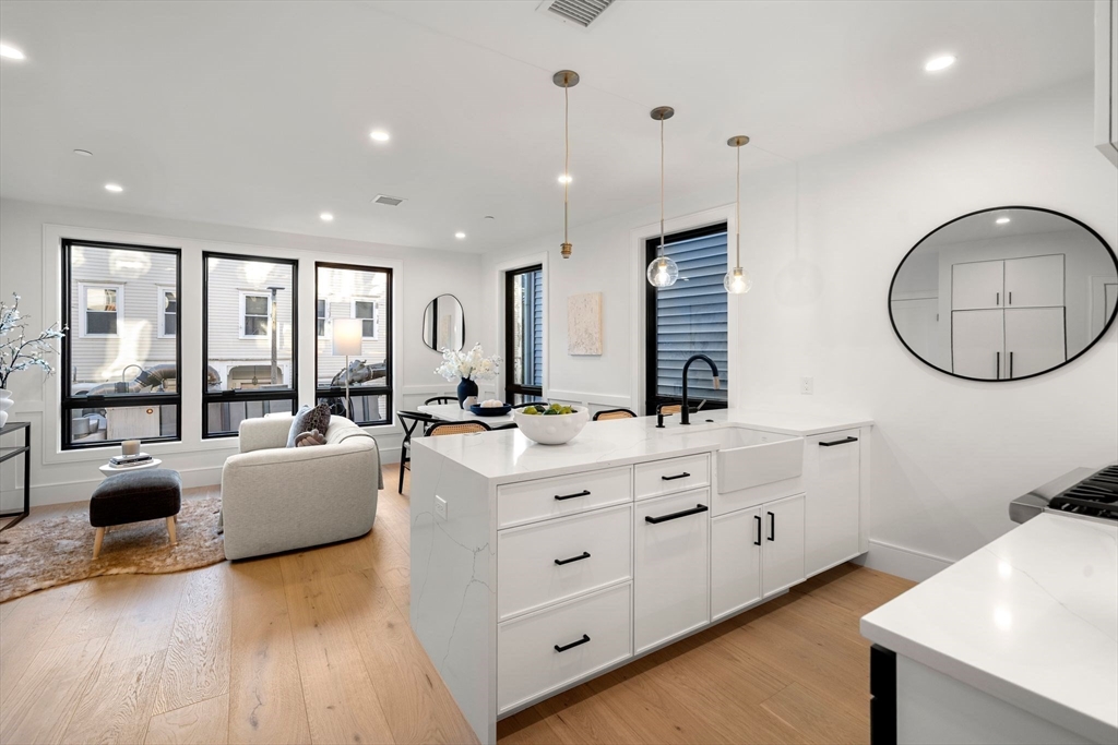 136 West 8th Street, Unit 2 Boston, MA 02127 - Photo 2 of 14 a large room with a large window and a wooden floor