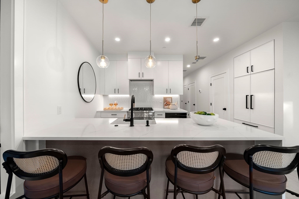 136 West 8th Street, Unit 2 Boston, MA 02127 - Photo 6 of 14 a kitchen with a table chairs sink and cabinets