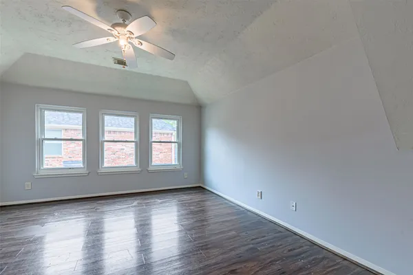 an empty room with wooden floor and window