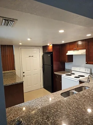 a kitchen with a refrigerator and a stove top oven