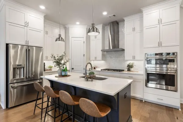 a kitchen with granite countertop a sink stove and refrigerator