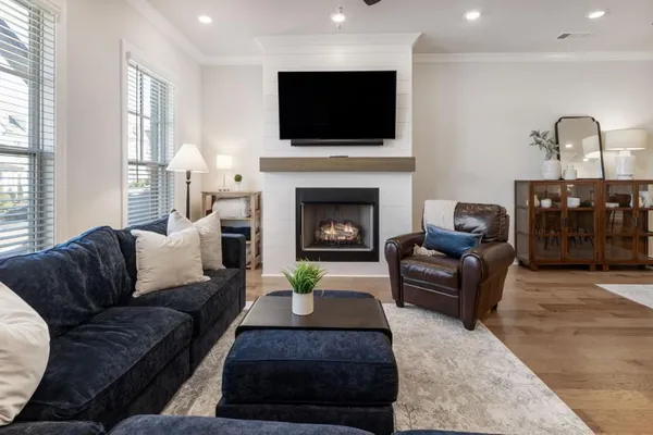 a living room with furniture a flat screen tv and a fireplace