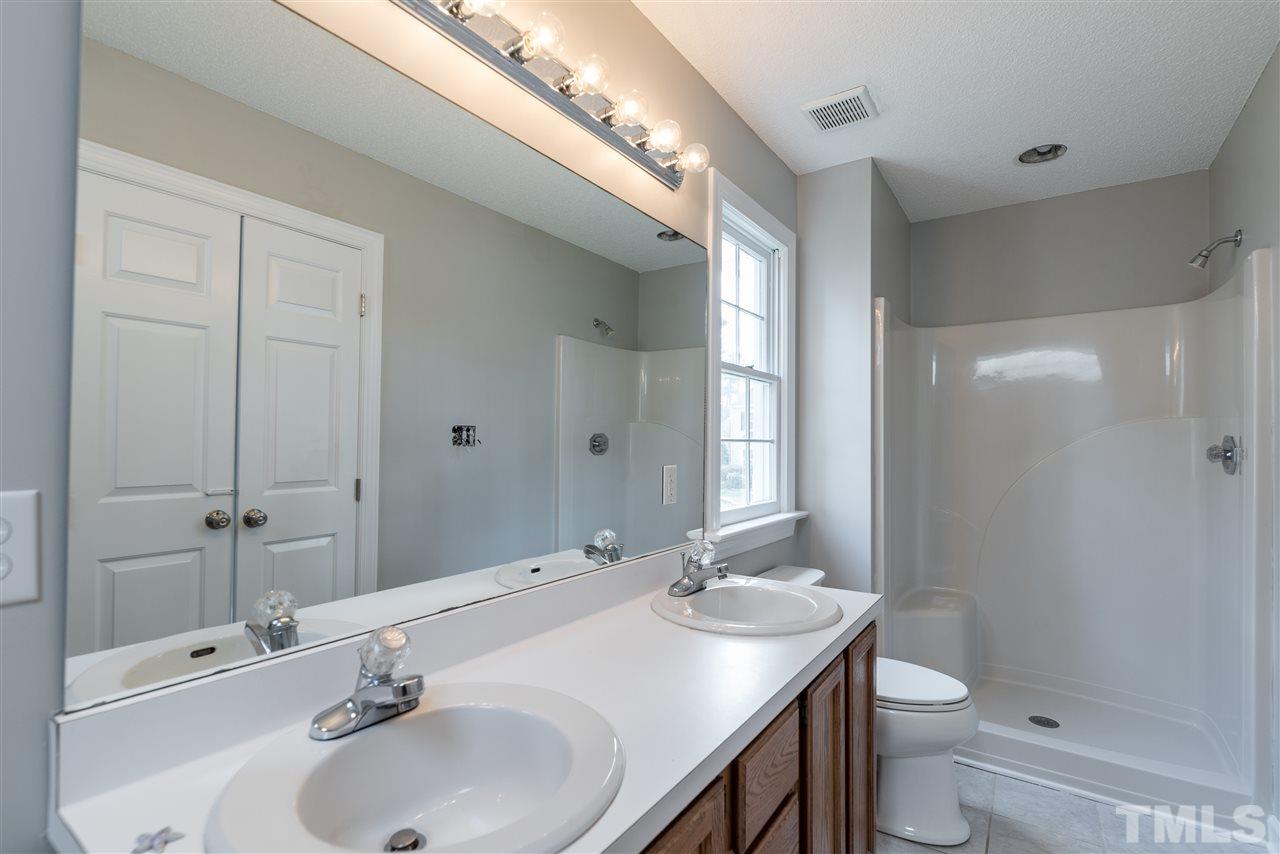 4237 Dinwiddie Court Raleigh, NC 27604 - Photo 19 of 25 a bathroom with a double vanity sink toilet and a mirror