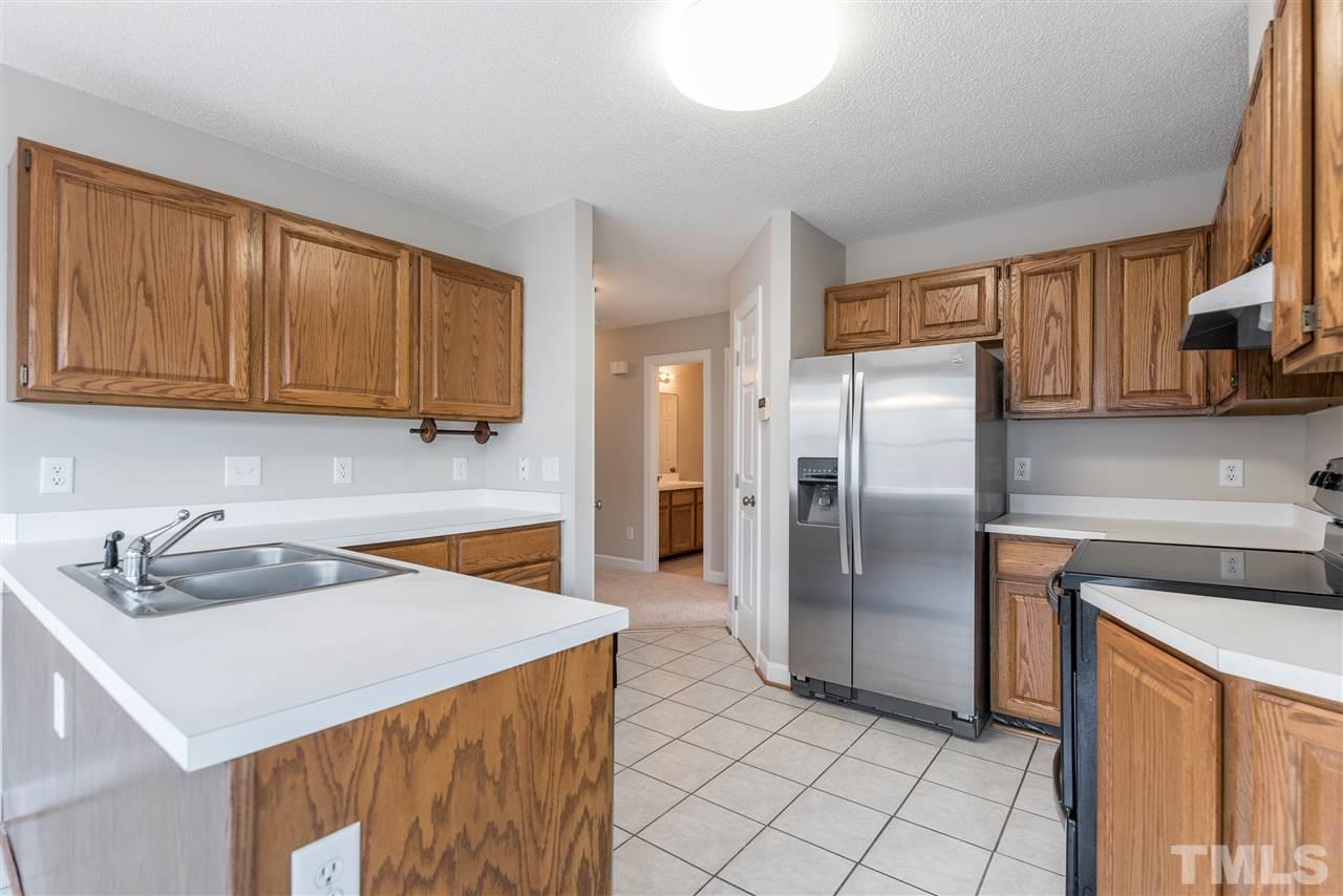 4237 Dinwiddie Court Raleigh, NC 27604 - Photo 10 of 25 a kitchen with stainless steel appliances granite countertop a sink a refrigerator and a stove